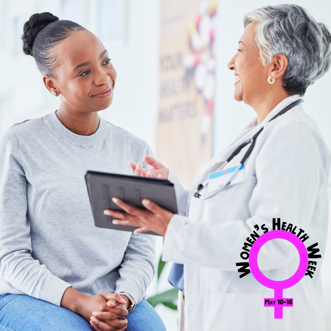 Medical exam room with a young black woman patient smiling and older woman healthcare provider holding a tablet and smiling broadly. A pink female symbol with Women's Health Week May 10-16 written in black is overlaid on the photo.